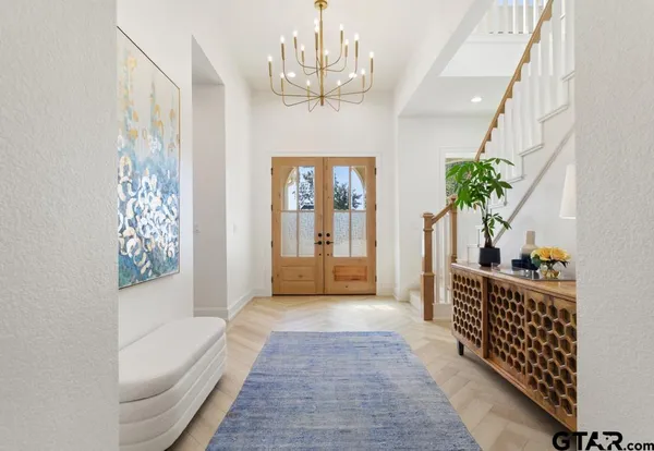 a hallway with windows and chandelier