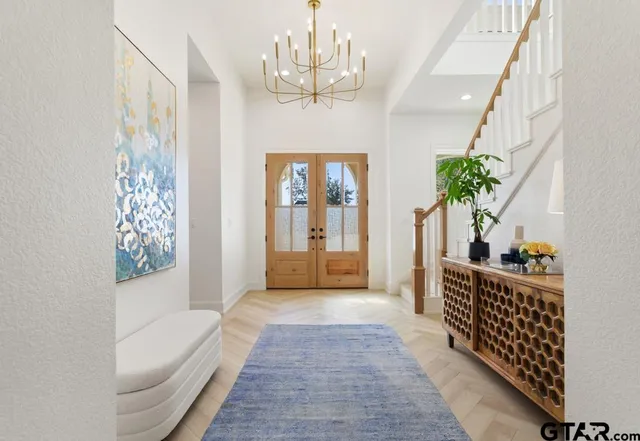 a hallway with windows and chandelier