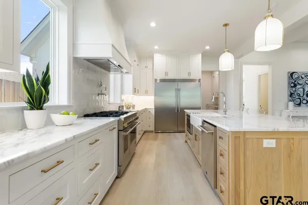 a kitchen with stainless steel appliances kitchen island granite countertop a sink a counter space and cabinets