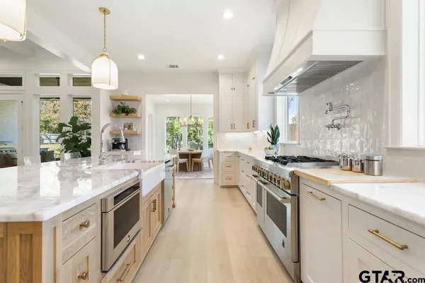 a large kitchen with stainless steel appliances granite countertop a lot of counter space and wooden floors