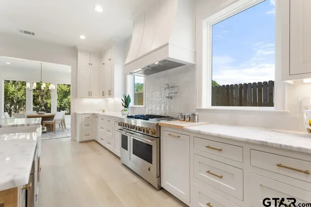 a kitchen with a stove a sink and a wooden cabinets