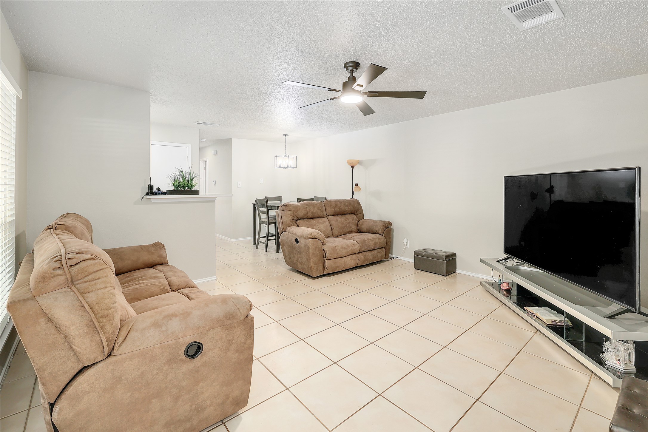 9906 Parliament House Road Austin, TX 78729 - Photo 6 of 33 Tiled flooring and neutral walls define this versatile open living space.