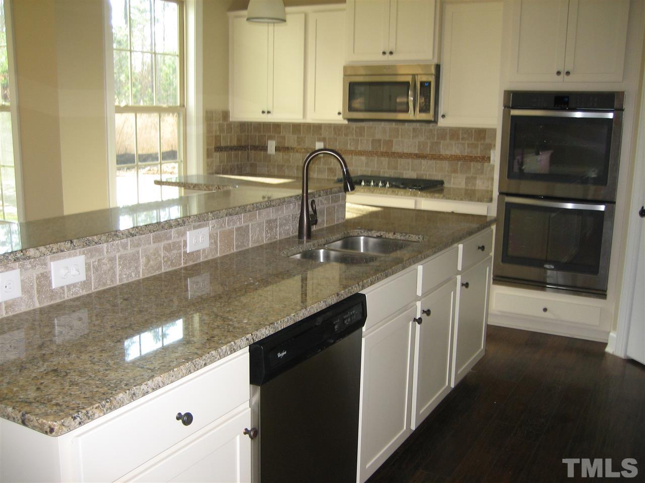3618 Greenville Loop Road Wake Forest, NC 27587 - Photo 9 of 25 Large L-Shaped Island w/breakfast bar. Rubbed Oil Bronze fixtures throughout home. Beautiful