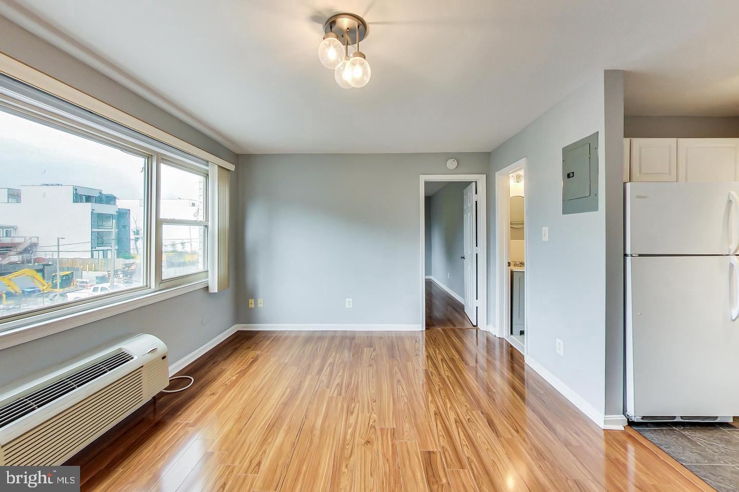 604 Longfellow Street Northwest, Unit 303 Washington, DC 20011 - Photo 5 of 12 a view of hallway with a large window and wooden floor