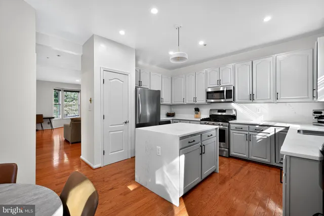 a kitchen with stainless steel appliances granite countertop a refrigerator stove microwave and sink