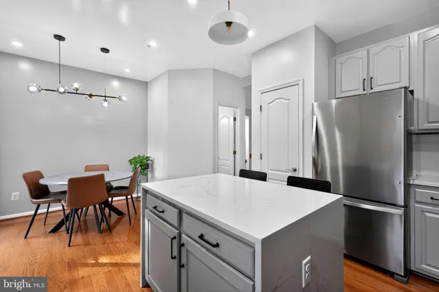 a kitchen with stainless steel appliances a refrigerator a table and chairs
