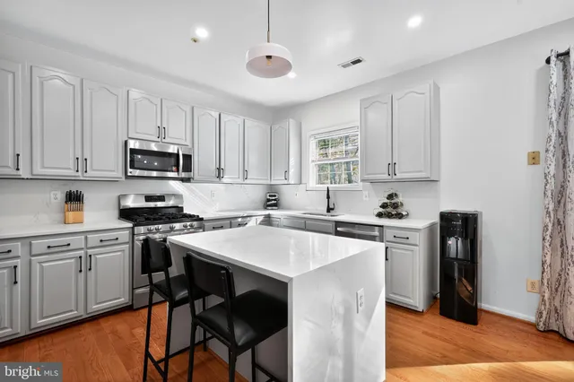 a kitchen with stainless steel appliances granite countertop a stove top oven a refrigerator a sink and a stove