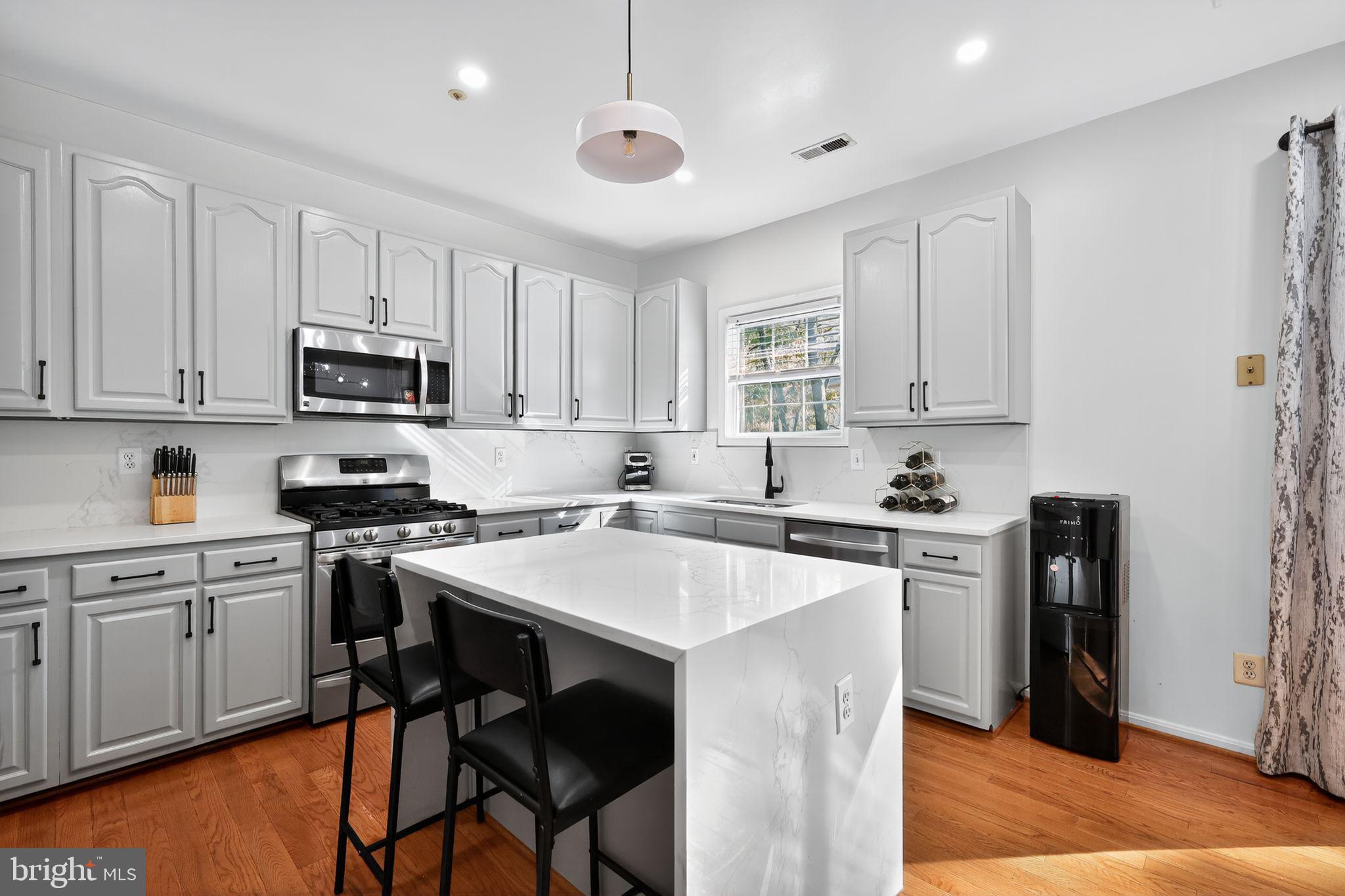1707 Severn Tree Court Severn, MD 21144 - Photo 15 of 37 a kitchen with stainless steel appliances granite countertop a stove top oven a refrigerator a sink and a stove