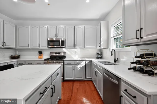 a kitchen with stainless steel appliances granite countertop a sink stove and cabinets