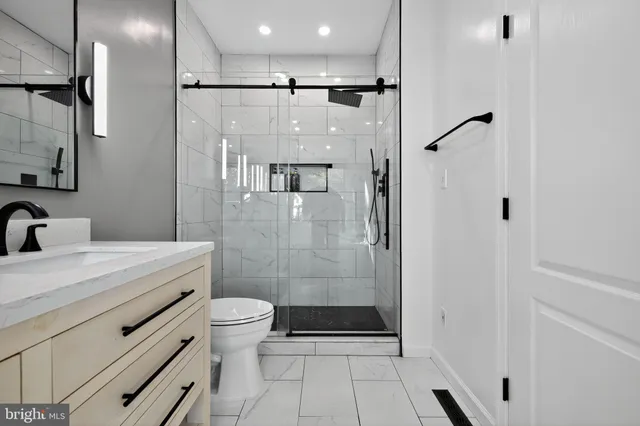 a bathroom with a double vanity sink toilet and shower