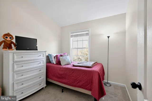 a bedroom with a bed and a flat tv screen on a dresser