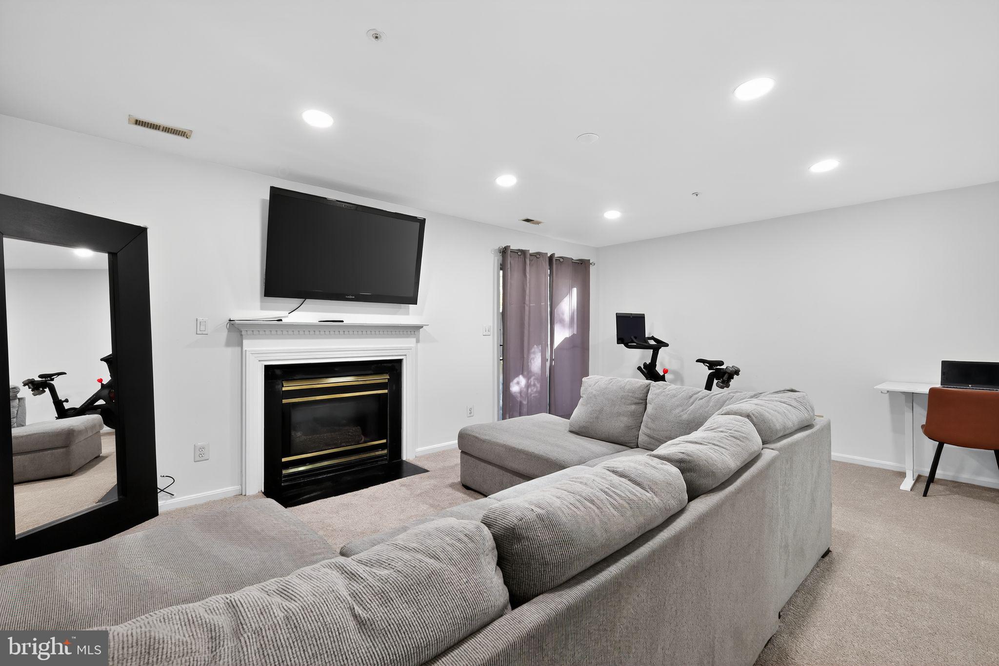 1707 Severn Tree Court Severn, MD 21144 - Photo 5 of 37 a living room with furniture a fireplace and a flat screen tv