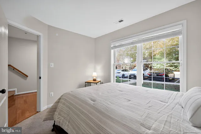 a bedroom with a bed and a large window