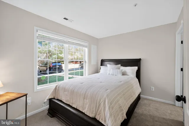 a large bed sitting in a bedroom next to a window