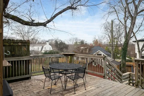 a view of a roof deck with table and chairs with wooden floor and fence