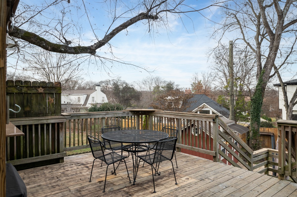 1002 Sutton Hill Road Nashville, TN 37204 - Photo 34 of 40 a view of a roof deck with table and chairs with wooden floor and fence