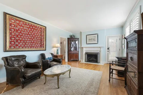 a living room with furniture a fireplace and wooden floor