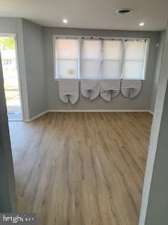 a view of a room with wooden floor and window
