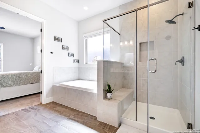 a bathroom with a tub shower and mirror