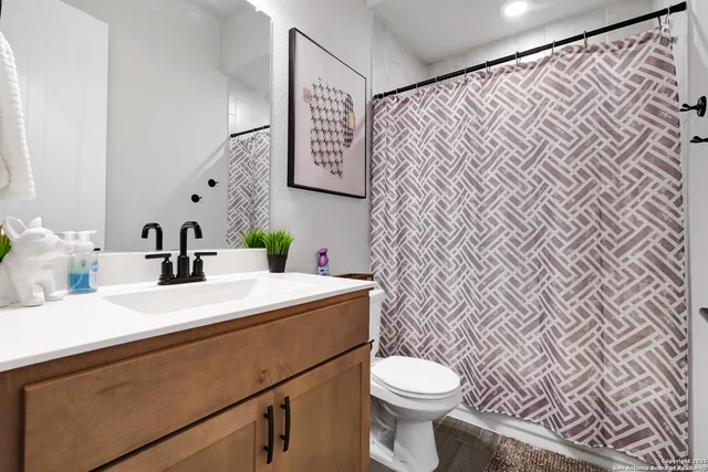 a bathroom with a sink a toilet and a mirror