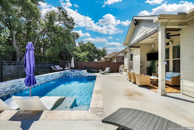 a view of a patio with couches and table and chairs with wooden fence and plants