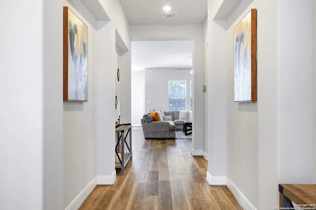 a hall way with wooden floor and furniture