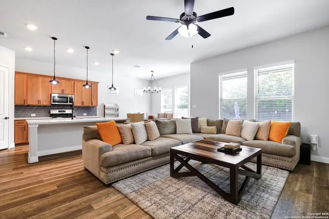 a living room with furniture kitchen view and a large window