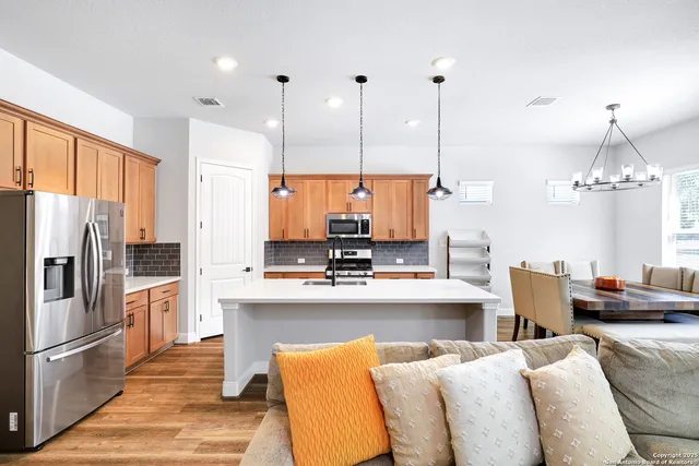 a kitchen with stainless steel appliances granite countertop a refrigerator a sink dishwasher a kitchen island with chairs and cabinets