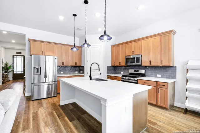 a kitchen with stainless steel appliances a refrigerator sink and microwave