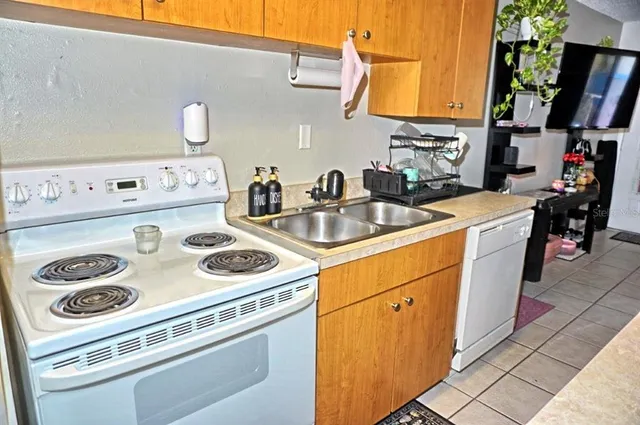 a kitchen with sink a refrigerator and cabinets
