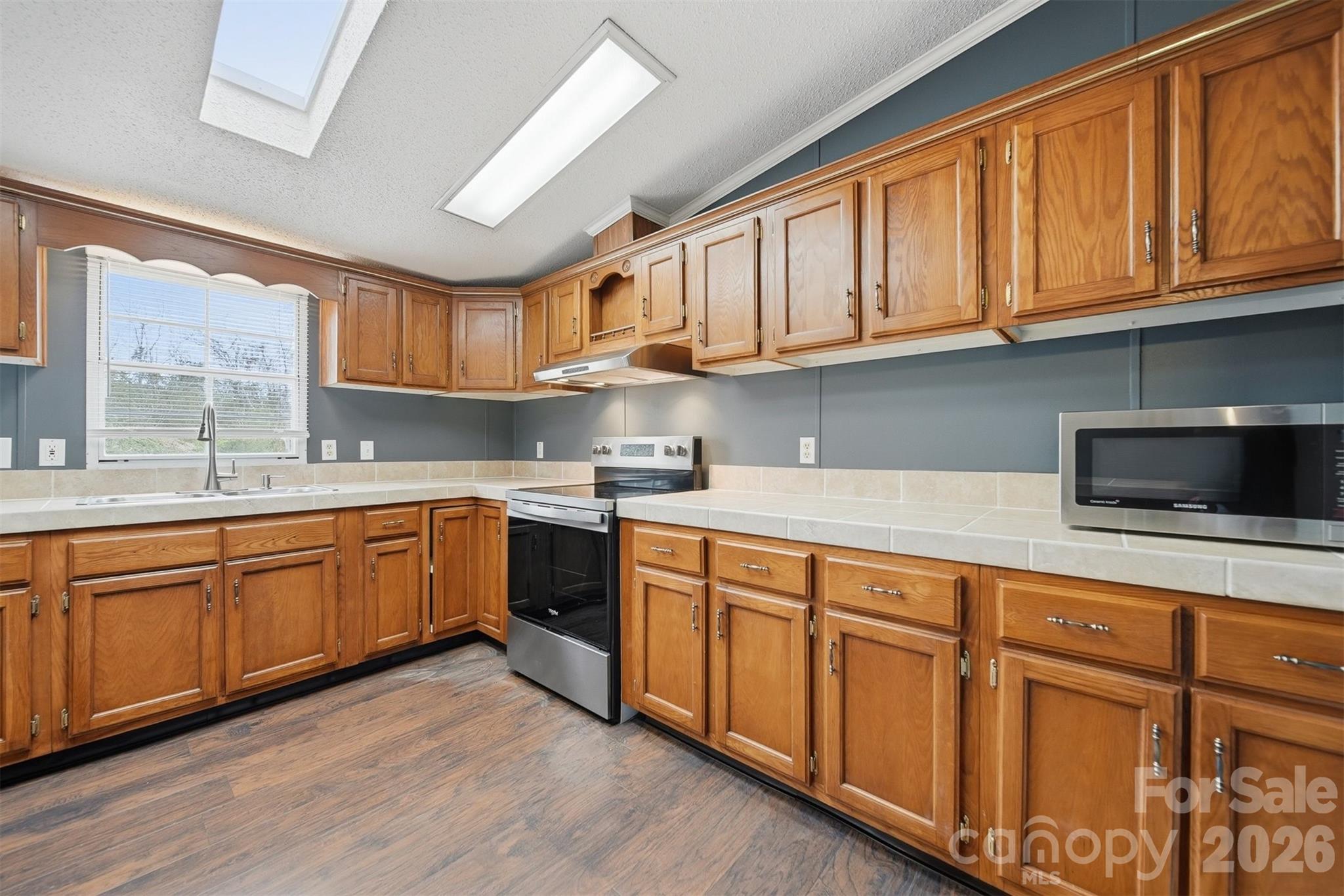 315 West McDowell Street Morganton, NC 28655 - Photo 14 of 48 a kitchen with stainless steel appliances granite countertop a sink dishwasher stove and cabinets with wooden floor