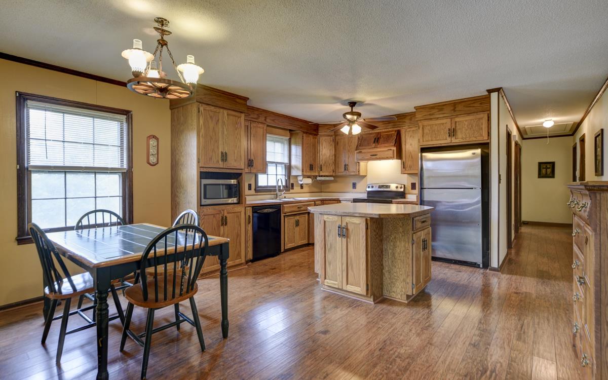 6246 Arno Road Franklin, TN 37064 - Photo 8 of 29 a kitchen with stainless steel appliances granite countertop a stove top oven a sink dishwasher a dining table and chairs with wooden floor