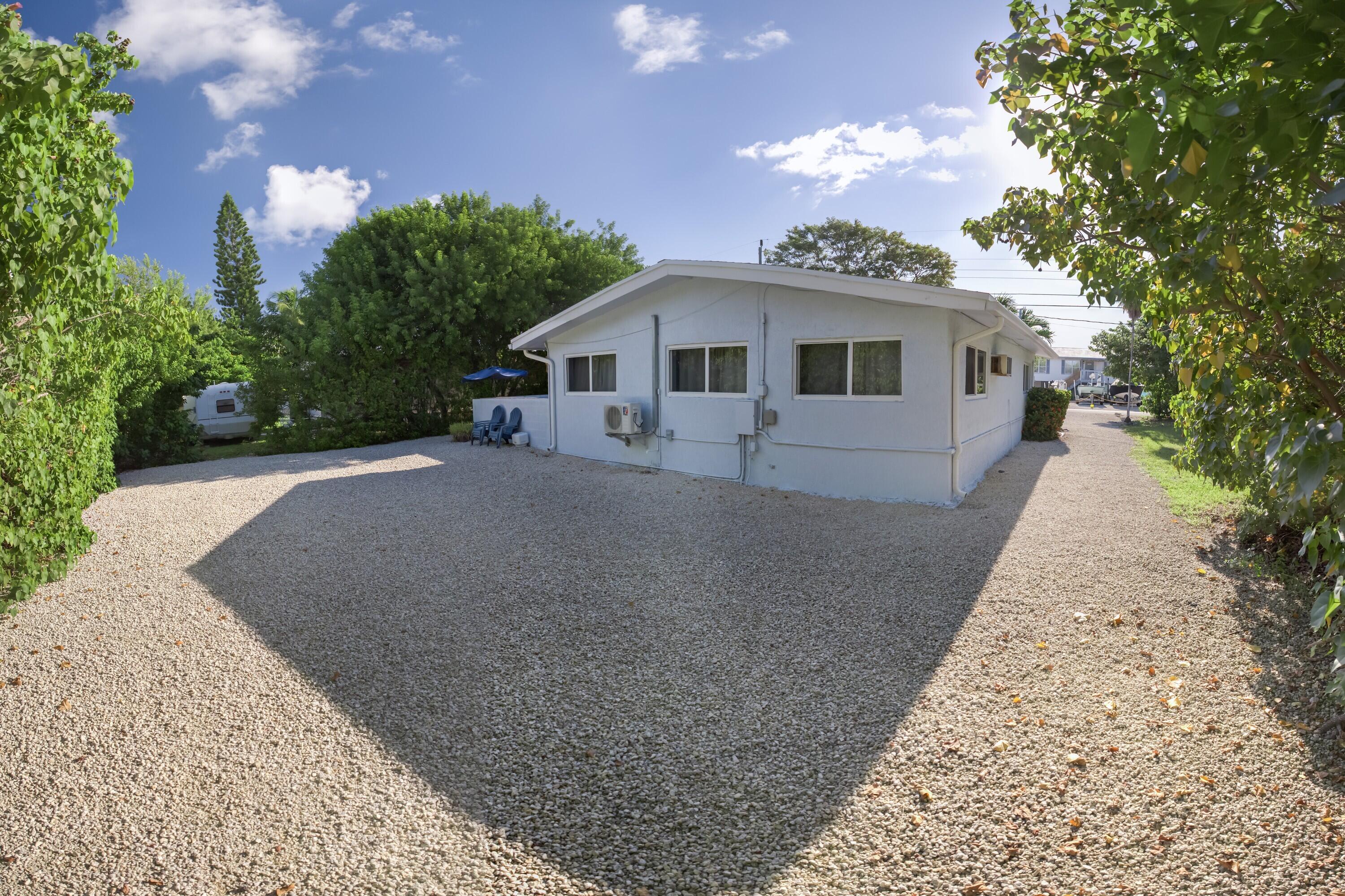 423 80th Street Marathon, FL 33050 - Photo 7 of 39 a front view of a house with a yard and trees