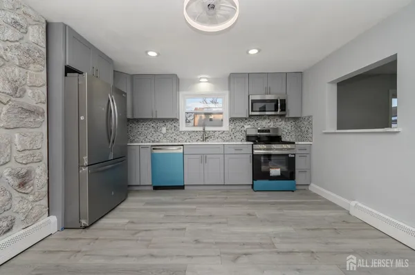 a kitchen with stainless steel appliances granite countertop a stove a sink and a refrigerator
