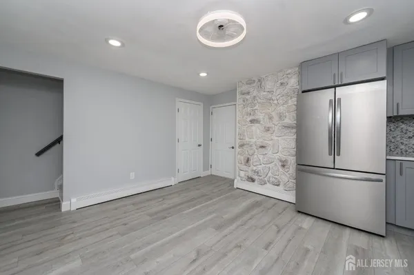 a view of a kitchen with a refrigerator and a stove top oven