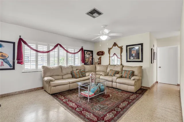 a living room with furniture a rug and a window