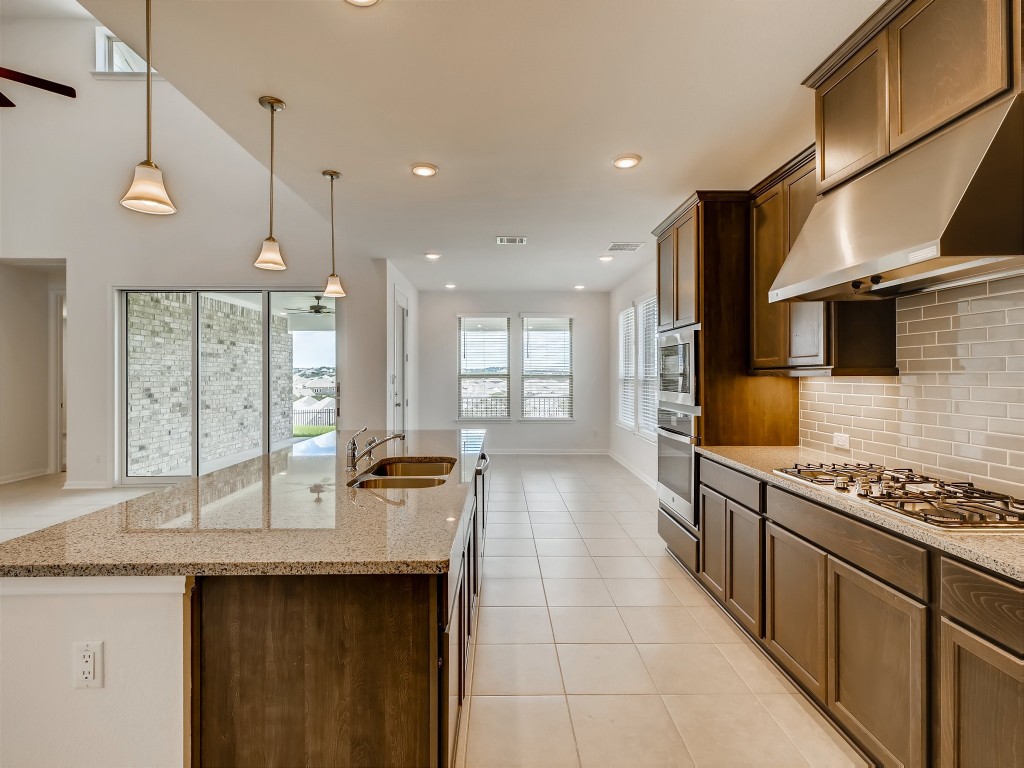 334 Pecos River Crossing Dripping Springs, TX 78620 - Photo 10 of 28 a kitchen with stainless steel appliances a sink stove and cabinets