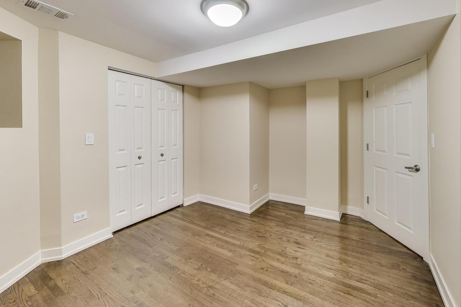 4432 North Dover Street, Unit 1S Chicago, IL 60640 - Photo 27 of 30 a view of an empty room with wooden floor