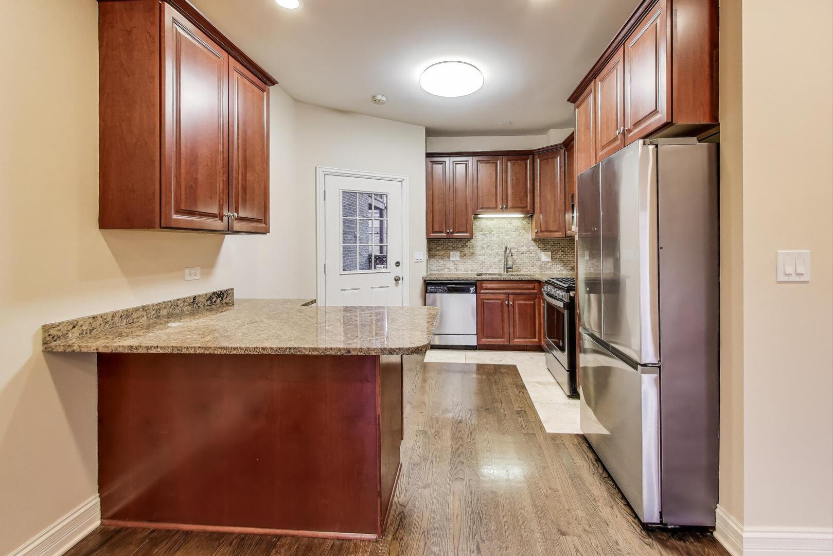 4432 North Dover Street, Unit 1S Chicago, IL 60640 - Photo 7 of 30 a kitchen with granite countertop a refrigerator and a sink