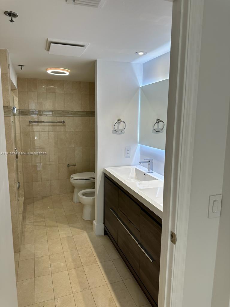 251 Crandon Boulevard, Unit 430 Key Biscayne, FL 33149 - Photo 14 of 19 a bathroom with a granite countertop sink a toilet and shower