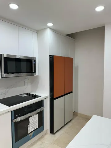 a kitchen with stainless steel appliances a stove microwave and sink