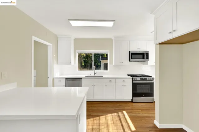 a kitchen with stainless steel appliances granite countertop a stove a sink and a refrigerator