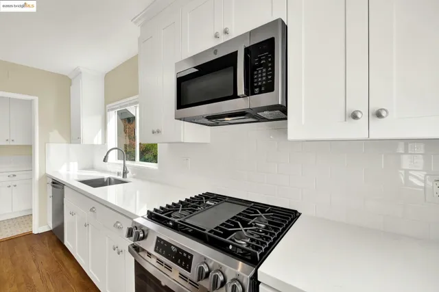 a kitchen with stainless steel appliances a sink a stove and microwave