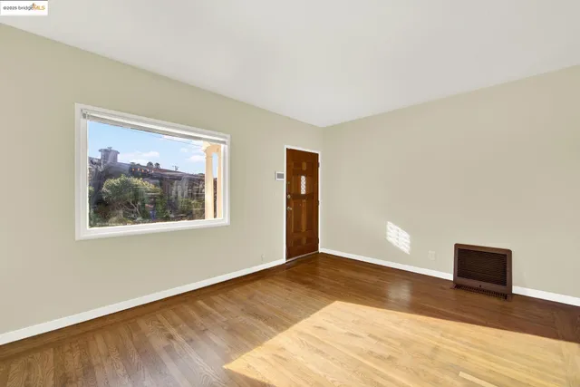 a view of a hallway with wooden floor and a kitchen space