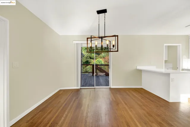 a view of empty room with wooden floor and window
