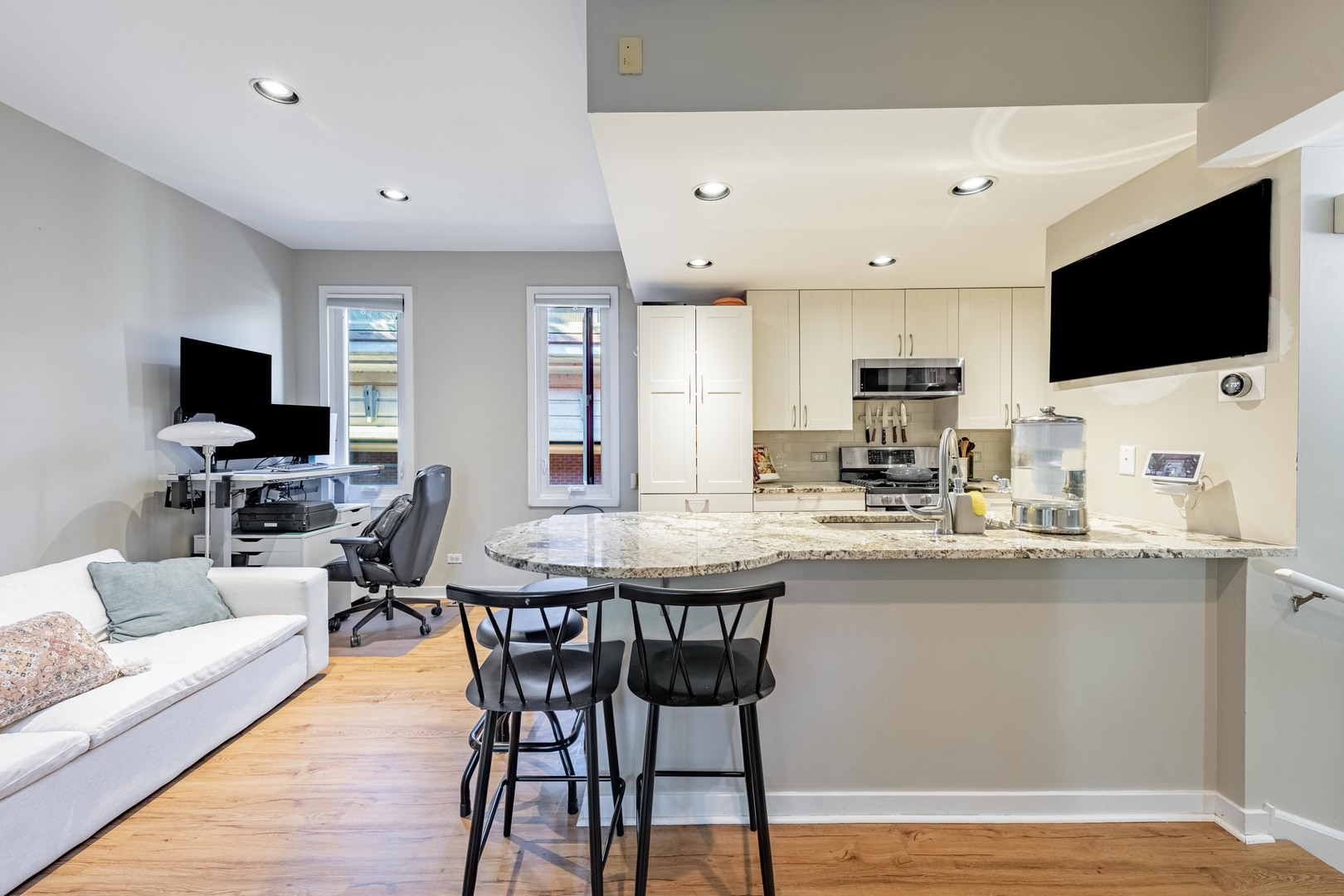 1200 South Federal Street, Unit C Chicago, IL 60605 - Photo 8 of 20 a kitchen with stainless steel appliances kitchen island granite countertop a sink and a stove top oven with wooden floor