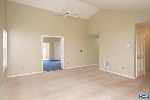 an empty room with windows and fan