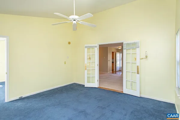 an empty room with windows and fan