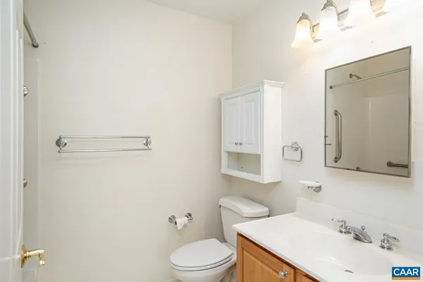 an empty room with chandelier fan and windows