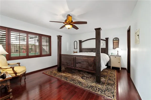 a bedroom with a bed a dresser and a chandelier